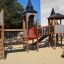 Zitadelle Spielplatz mit Spieltürmen, Brücke und Spiralrutschen im Freien.