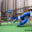 Zitadelle Spielplatz mit Spieltürmen, blauen Spiralrutschen und grünem Bodenbelag.
