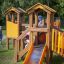 Kinder spielen auf einem Alpha Barrierefreie Spielplatz mit Rutsche und Kletterturm.