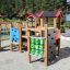 Barrierefreier Spielplatz Alpha mit Holzkonstruktion und Spielaktivitäten für Kinder.