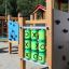 Kinderspielplatz mit Tic-Tac-Toe-Spiel und Klettergerüsten im Hintergrund