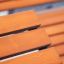 Nahaufnahme des Montpellier Liegestuhl mit Holzlamellen in Orange.