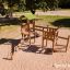 Holzdreieck-Spielturm mit Rutsche und Kletterelementen auf einem Sandplatz.