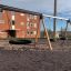 Dreifache Schaukel mit Nest-Sitz auf einem Kinderspielplatz
