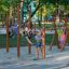 Kinder spielen an Reckstangen aus Holz auf einem Spielplatz im Freien.