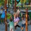 Kinder spielen auf Reckstangen im Spielplatz im Freien.