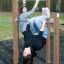Zwei junge Mädchen beim Spielen auf einer Reckstange im Park.