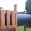 Eragon Spielanlage mit Tunnel und Rutsche aus Holz und Metall auf einem Spielplatz.