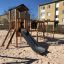 Eragon Spielanlage mit Tunnel und Rutsche auf einem Spielplatz mit Sandboden.