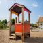 Spielhaus aus Holz auf einem Sandplatz im Freien