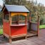 Farbenfrohes Spielhaus mit Veranda für Kinder im Garten.