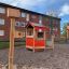 Spielhaus mit Veranda auf Spielplatz vor Wohngebäuden