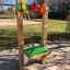 Kramladen Spielwand aus Holz mit bunten Spielelementen auf einem Spielplatz.
