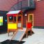 Buntes Spielhaus für Kinder mit Rutsche und Kletterwand.