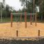 Sechseckige Schaukel Robinie auf einem Kinderspielplatz mit Holzspänen und umgebender Natur.