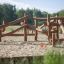 Klettergerüst aus Robinienholz für Kinder, natürliches Design auf Sandboden im Freien.