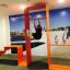 Mann trainiert an einer Stahlband Fitness II Anlage in leuchtend orangem Rahmen.