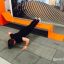 Mann macht Liegestütze auf Stahlband Fitness II Gerät in urbaner Umgebung