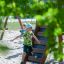 Zwei Kinder spielen auf einem Piraten Basis II Spielanlage mit Rutsche im Sand.