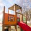 Kinder-Spielhaus mit Rutsche und eingebautem Gedächtnisspiel im Freien.