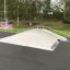 Skatepark Fun Box 8 aus Beton mit Metallgeländern in grüner Umgebung.