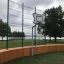 Holz-Multiarena mit Basketballkorb im Freien an einem bewölkten Tag.