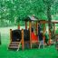 Kinderspielgerät Lokomotive Spielhaus aus Holz im grünen Garten mit Kindern beim Spielen.