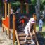 Kinder spielen auf einem Spielplatzzug namens Lokomotive Spielhaus in einem Park.