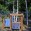 Kinder-Spielgerät Kapitänsbrücke im Freien mit Holzstruktur und Ruder.