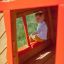 Junge liest ein Buch in einem bunten Spielhaus Annas Spielhaus im Garten.
