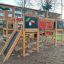 Dschungelcamp Klettergerüst mit Rutsche und farbenfrohen Tiermotiven auf einem Spielplatz.