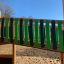 Holz-Klettergerüst Dschungelcamp mit grünen Kletterstangen auf einem Spielplatz.