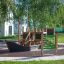 Holzspielplatz mit Rutsche, Kletterwand und Abakus im Freien.