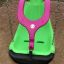 Grüner und pinker Schaukelsitz All Access Seat an Ketten auf einem Spielplatz.