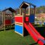 Farbenfroher Spielturm mit Klettergerüst, Schaukel und Rutsche im Garten