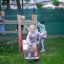 Kinder spielen auf einem Kastell Spielturm mit Rutsche im Garten.