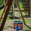 Kinder-Schaukelsitz in Rot und Blau auf einem Spielplatz