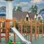 Grashüpfer Federwippe auf einem Spielplatz mit Klettergerüst und Rutsche.