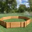 Holzspielplatz Oktagon Arena I auf grünem Kunstrasen, umgeben von Bäumen.