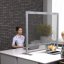 Gläserne Trennwand im Büro zwischen zwei Personen an einem Schreibtisch.