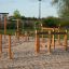 Spielplatz Trimm-dich-Pfade Holz-Klettergerüst und Balancierbalken auf Sandboden im Freien.