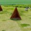 Tipi Spielhaus aus Holz im Kinderspielplatz mit Gras und Sandfläche.