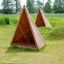 Tipi Spielhaus aus Holz auf grünem Spielplatz im Freien