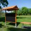 Outdoor Klassenraum Mit Holzbänken und Sonnenschutz Tafel im grünen Park