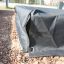 Schwarze Sandkastenabdeckung 2m x 2m auf Spielfläche aus Holzspänen.