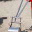 Nahaufnahme von Sandbagger barrierefrei mit Metallschaufel im Sand.