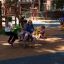 Kinder spielen auf einer Doppelte Pferde Federwippe auf einem Spielplatz.