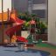 Doppelte Pferde Federwippe auf einem bunten Spielplatz mit Rutsche und Kletterturm.