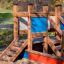 Holzspielplatz Kleines Schiff Sandkasten mit Rutsche in einem Park.