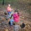Kinder spielen auf einem Fahrrad Federwippe im Herbstpark.